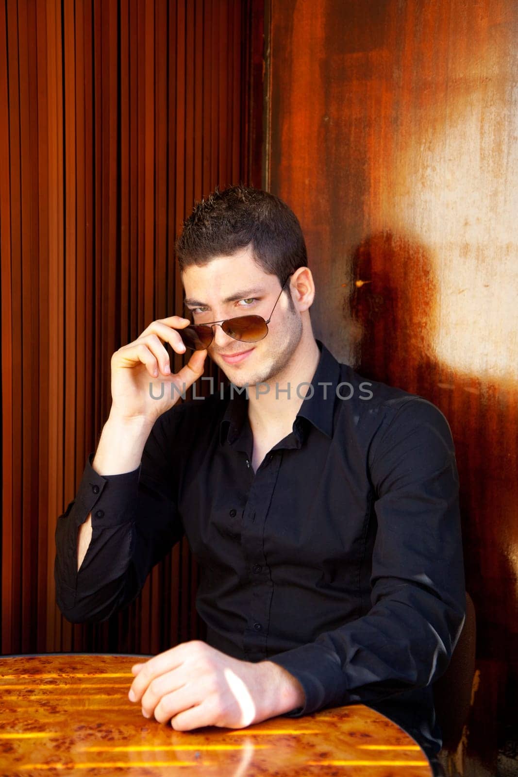 Latin mediterranean handsome man in wooden corner with sunglasses