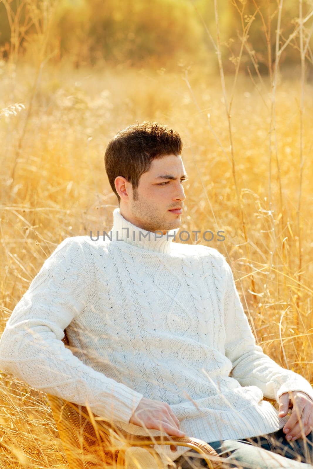 Autumn winter man portrait in outdoor dried grass field with turtleneck sweater