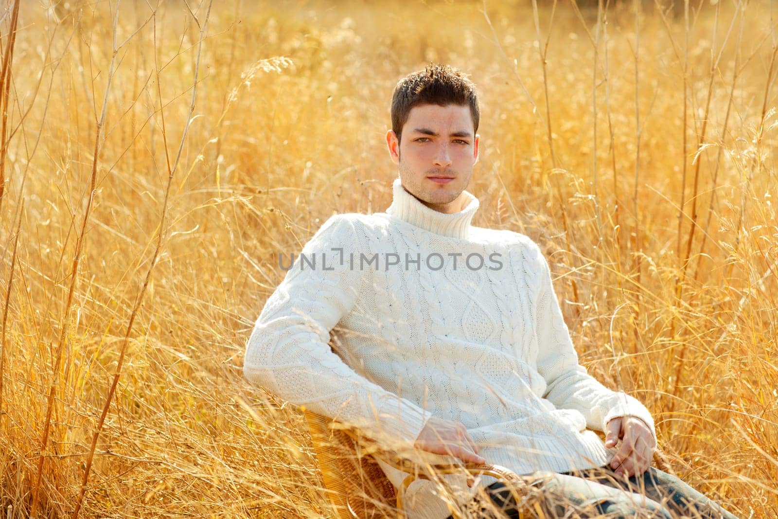 Autumn winter man portrait in outdoor dried grass field with turtleneck sweater