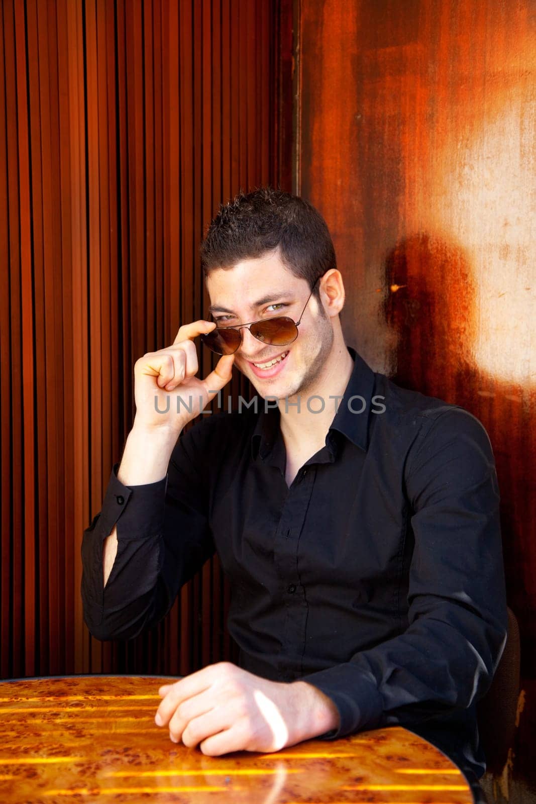 Latin mediterranean handsome man in wooden corner with sunglasses