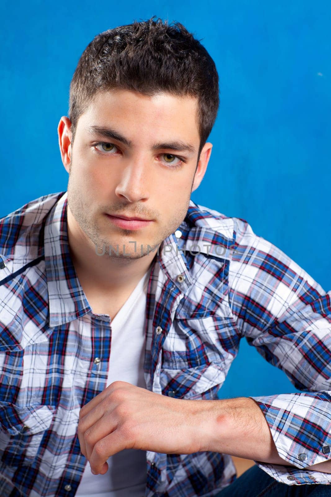 handsome young man with plaid shirt on blue background