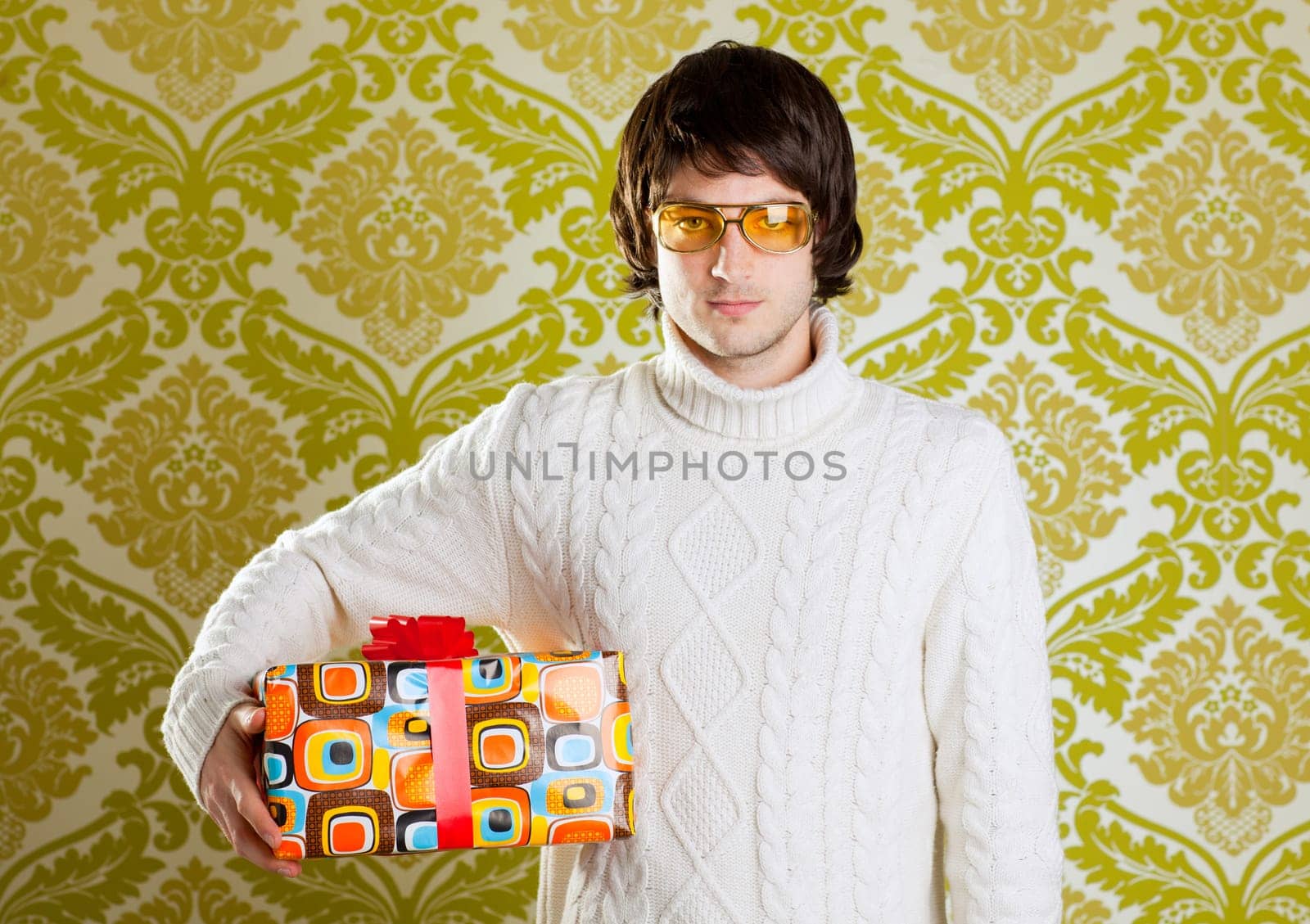 retro hip young man glasses holding  psychedelic gift box on wallpaper