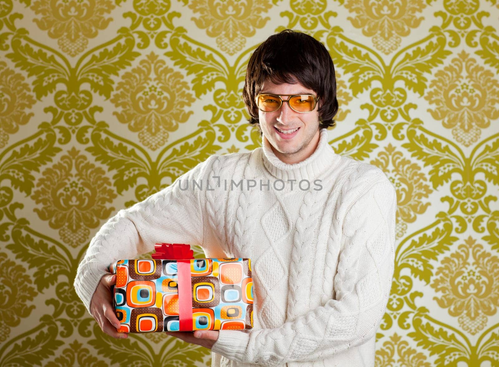 retro hip young man glasses holding  psychedelic gift box on wallpaper