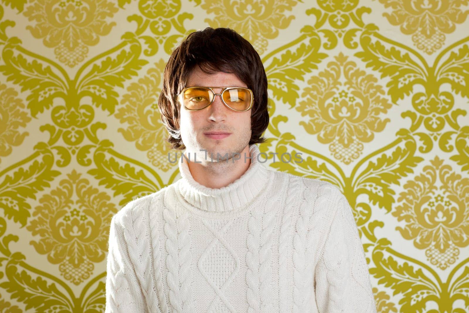 retro hip young man with vintage glasses and winter  turtleneck sweater on wallpaper