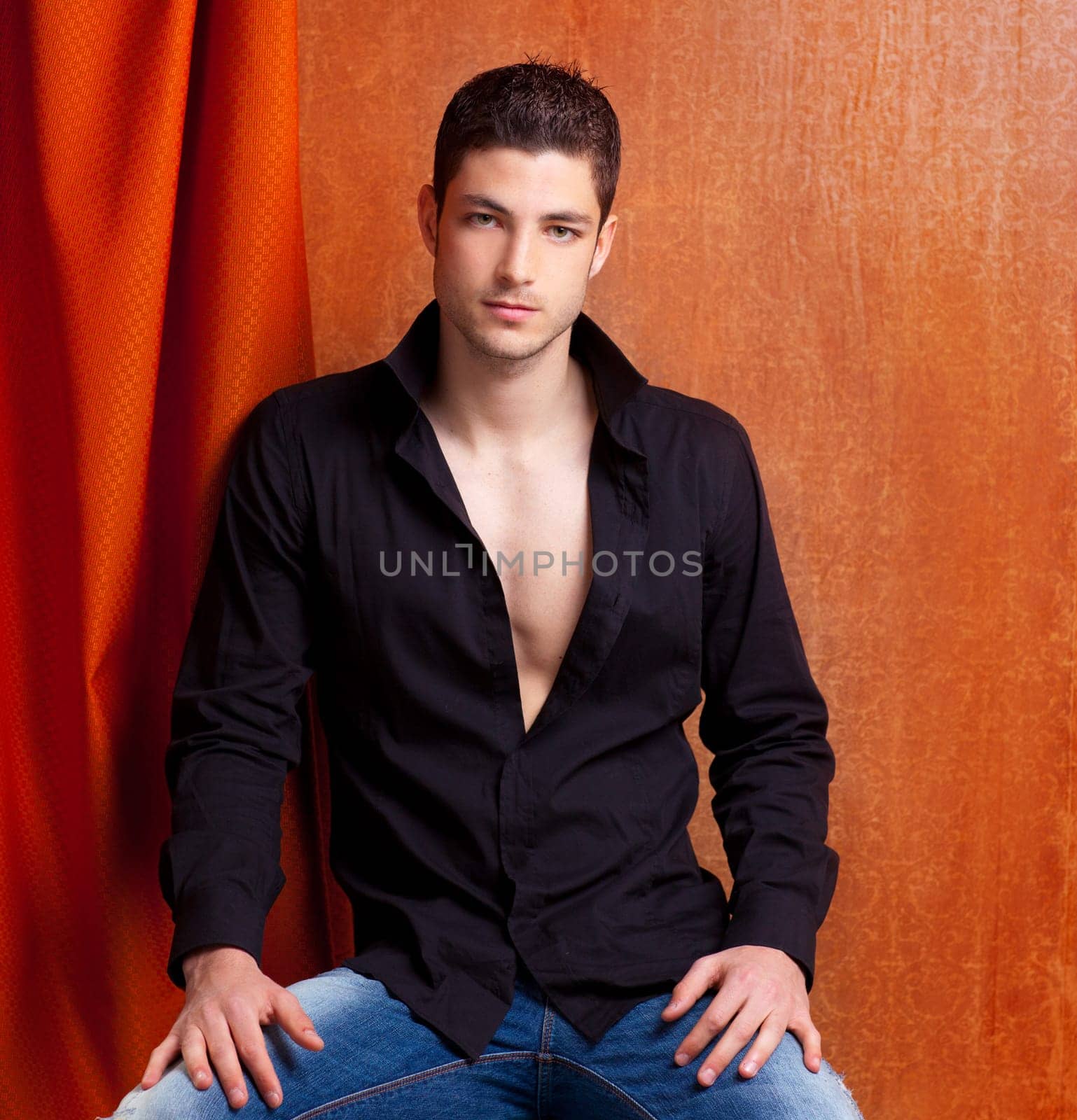 Latin spanish man portrait open black shirt with curtain and orange vintage background
