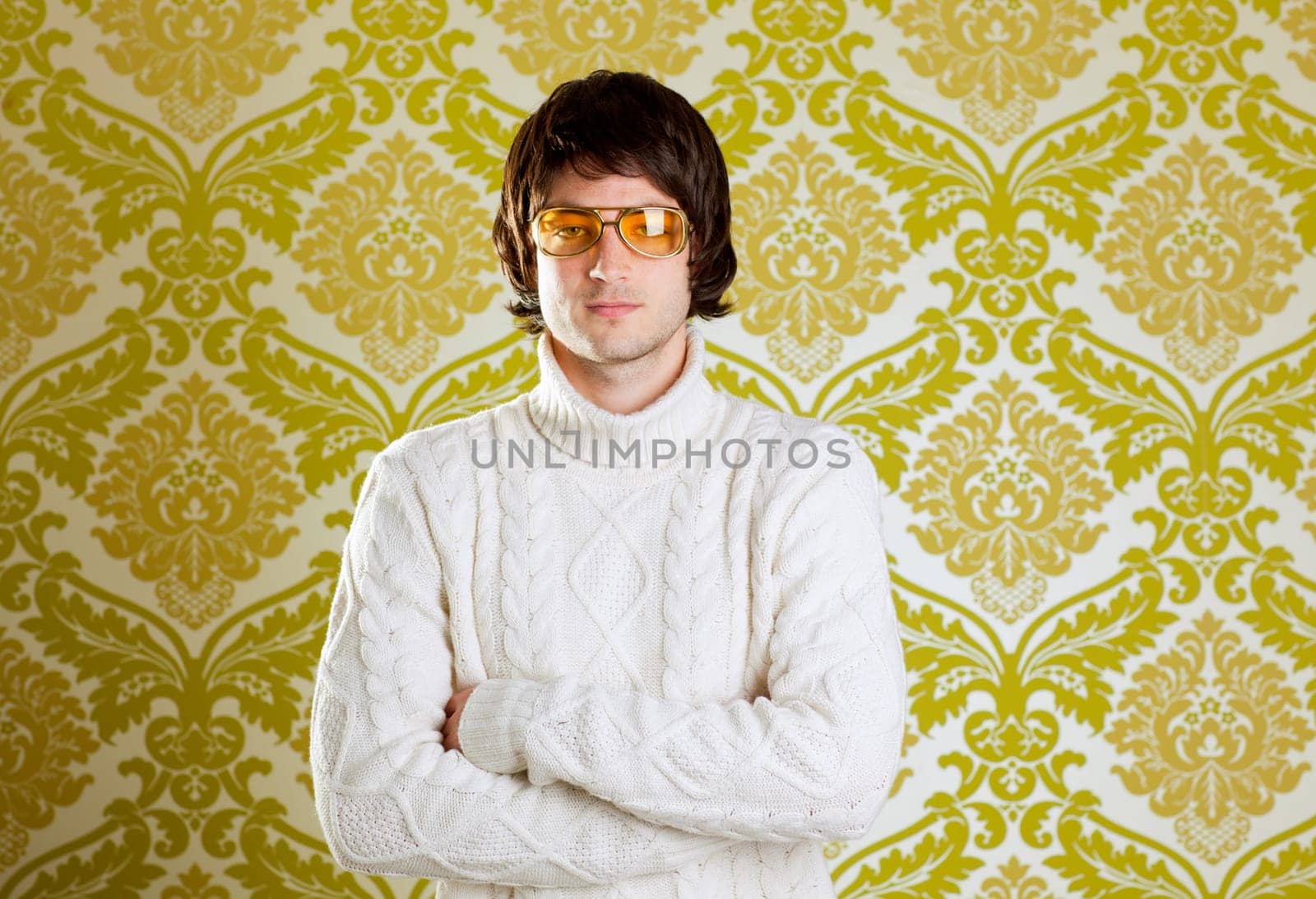 retro hip young man with vintage glasses and winter  turtleneck sweater on wallpaper