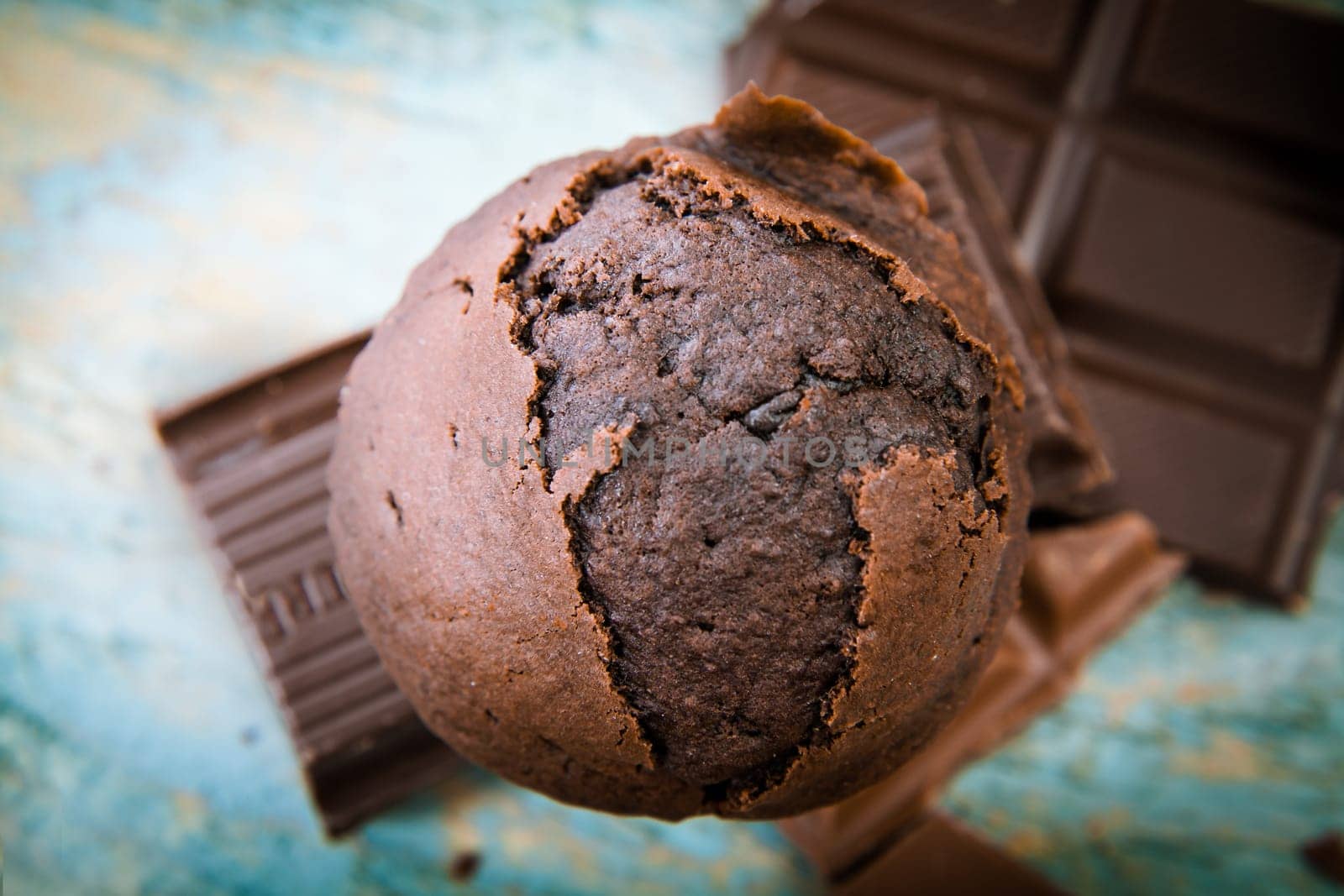 Overhead view of a freshly baked scrumptious chocolate muffin with pieces of chocolate