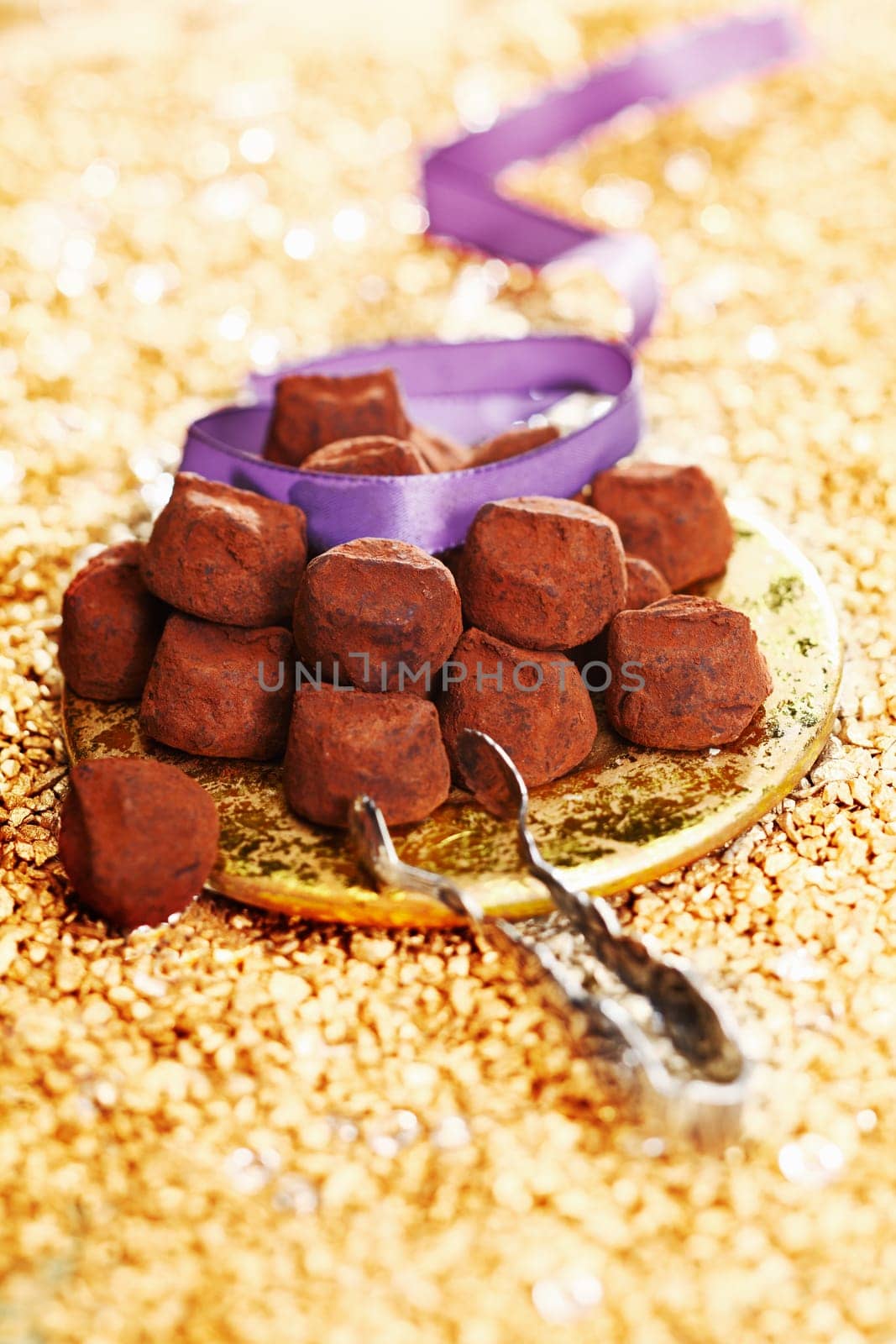 chocolate truffles with a ribbon on a festive golden background