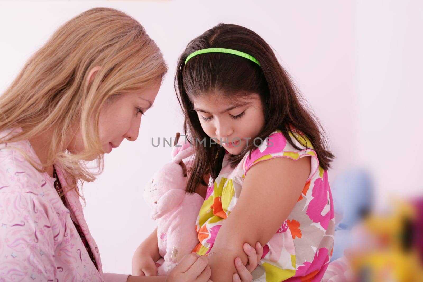 Doctor give injection to girl&#039 s arm, focus on the little girl.