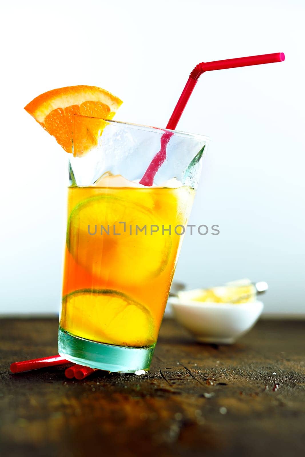Glass of summer cocktail with orange and tubule
