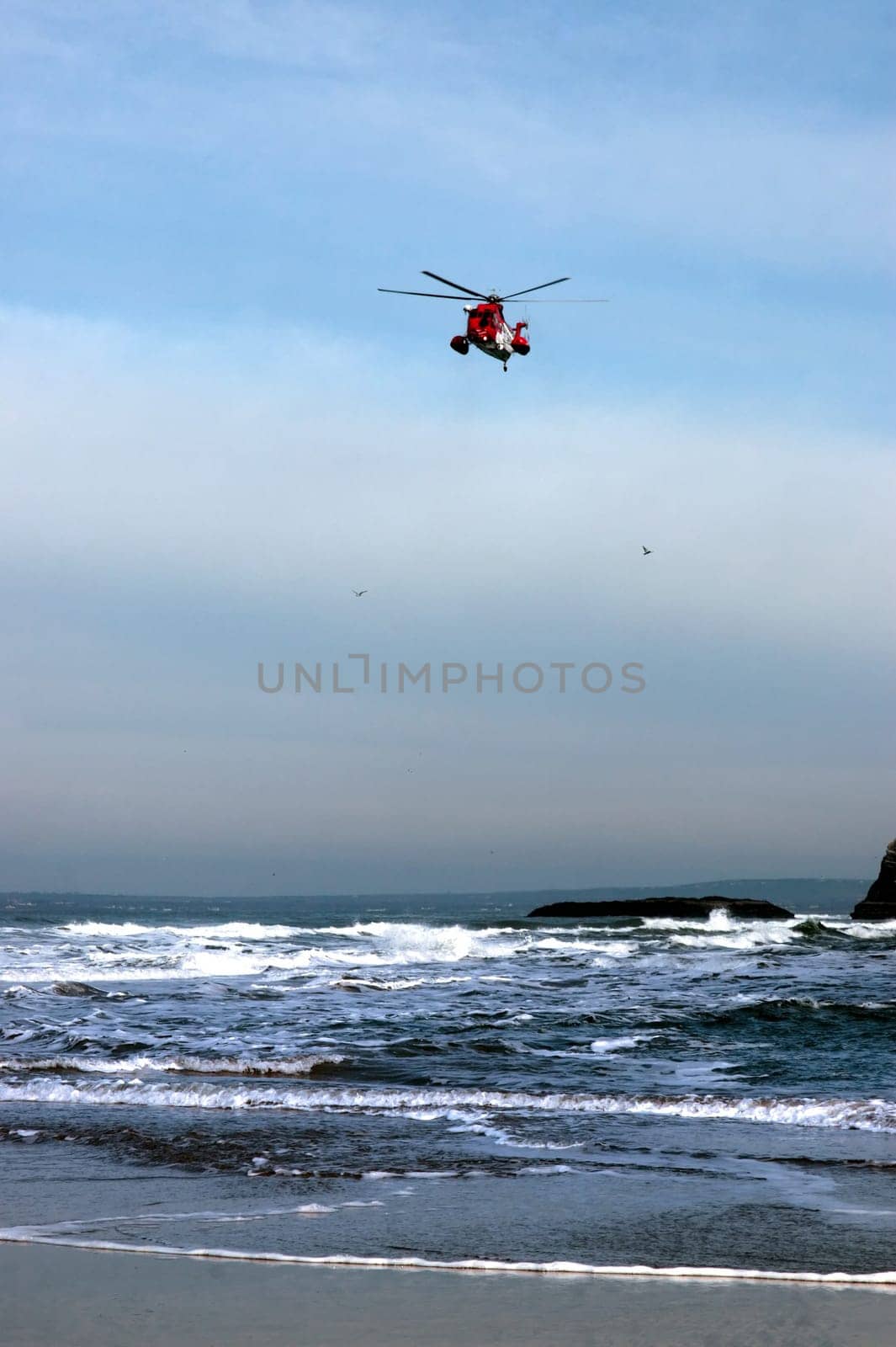 a sea rescue helicopter searching for person near to the cliffs on search and rescue mission in ballybunion county kerry ireland
