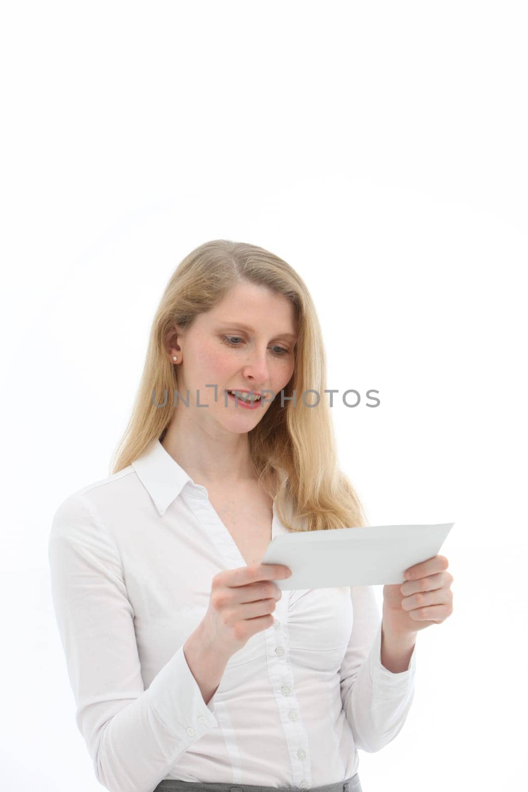 Young woman looking interestedly at an envelope against a white background