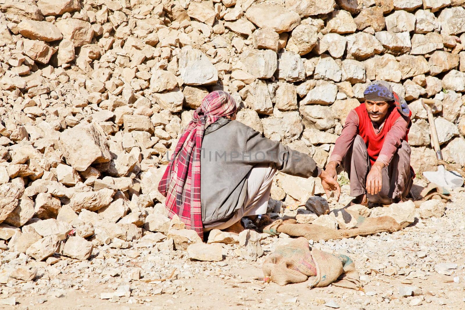 Shiva Kodi, Kashmir, India - December 18, 2011: Editorial, portrait of wall builders along the public foot path to Shiv Kodi hindu temple trying to work out who should gather rocks and who will carry, photograph, rendition, vtwo