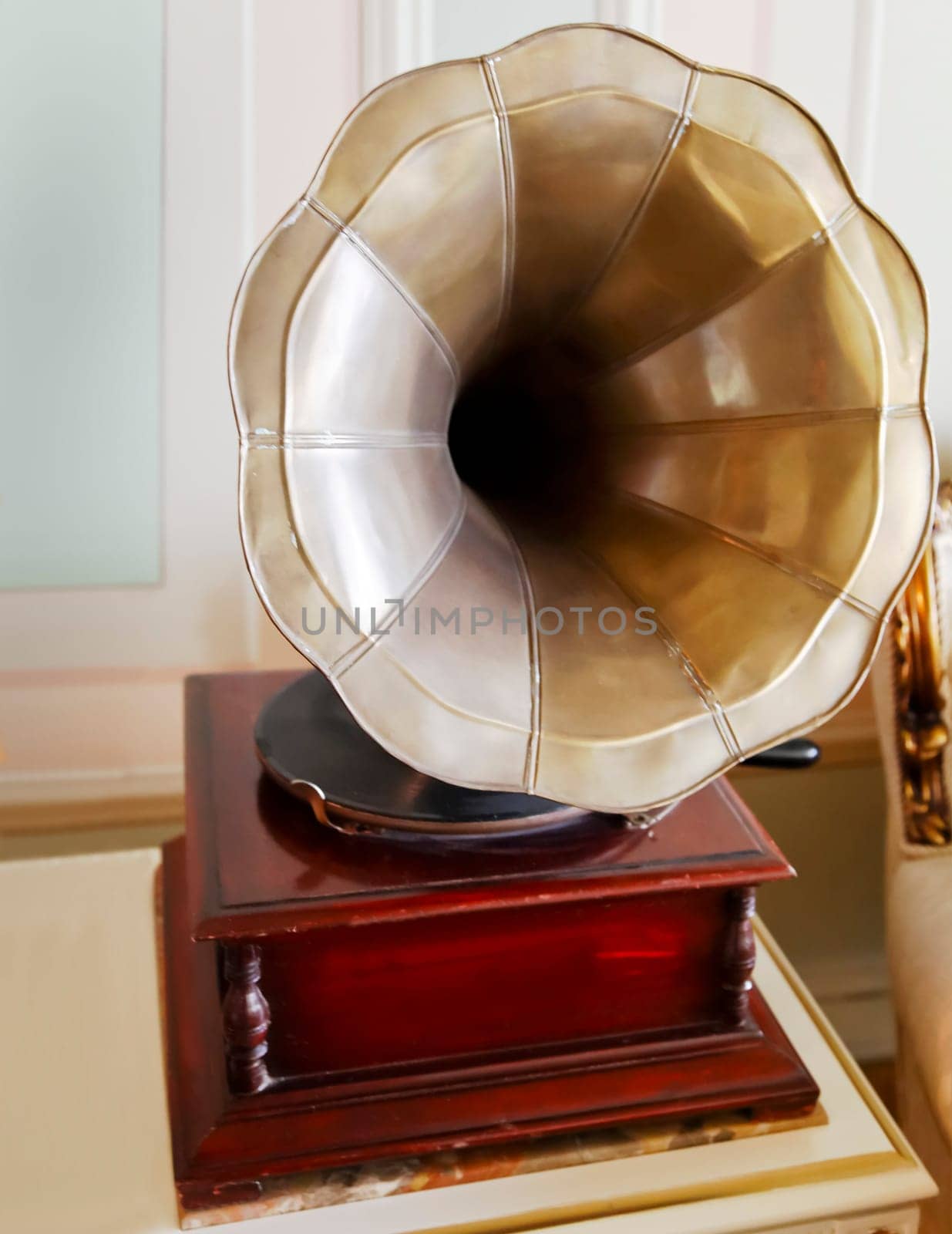 Portrait, old antiquated clockwork gramophone in a room interior setting on an occasional coffee table