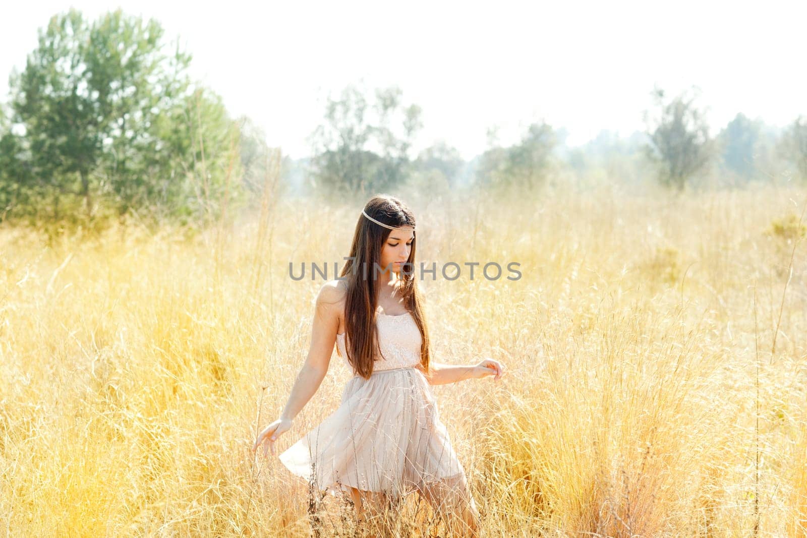 Asian indian woman walking in golden dried grass field