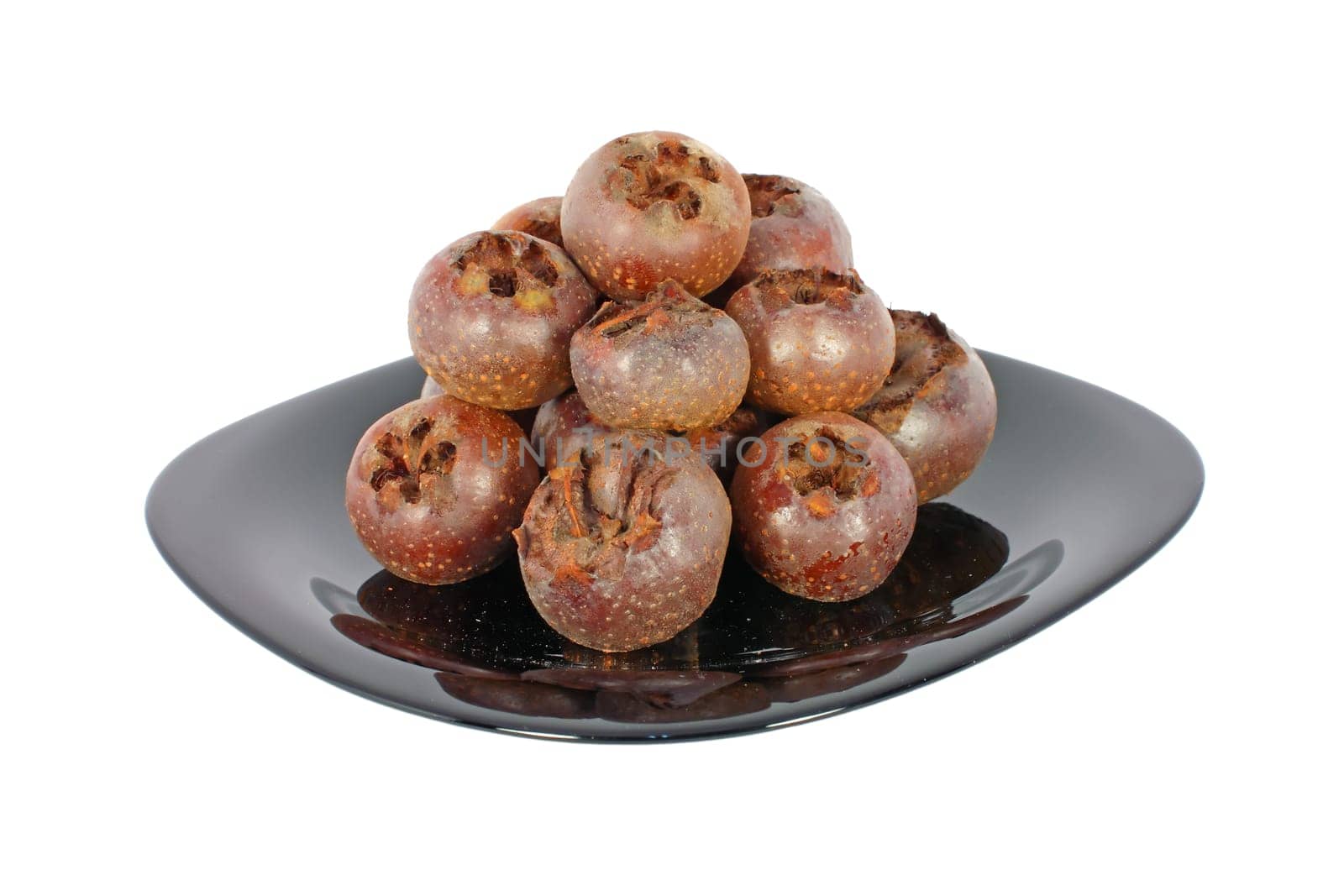Ripe medlar fruits on black plate isolated on white