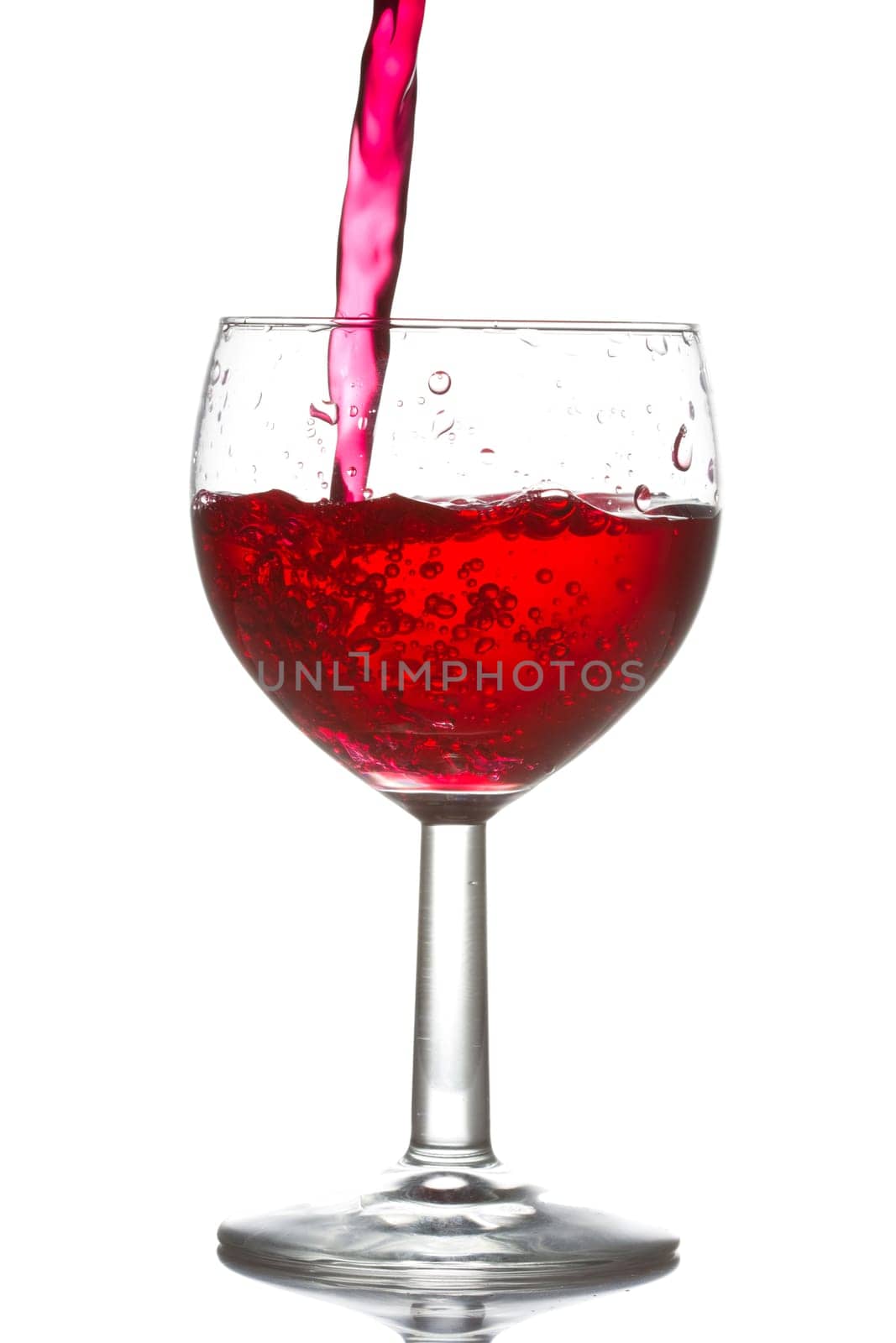 red wine pouring into glass over a white background