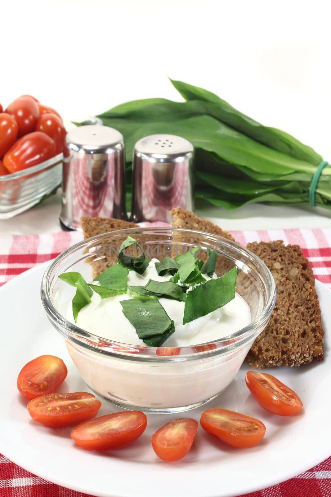 a bowl of wild garlic quark with bread and tomatoes