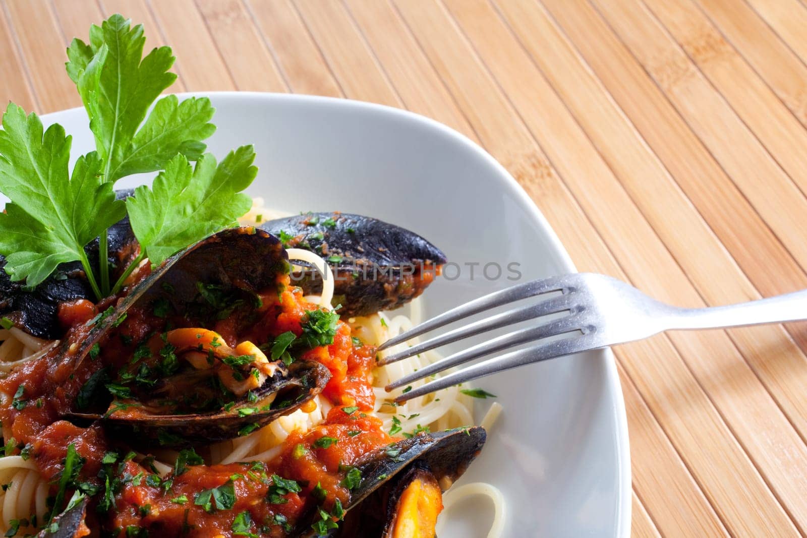 Spaghetti with mussels on wooden table