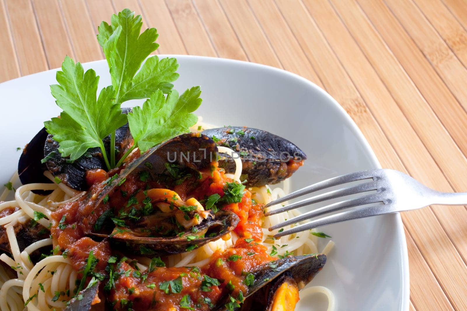 Spaghetti with mussels on wooden table