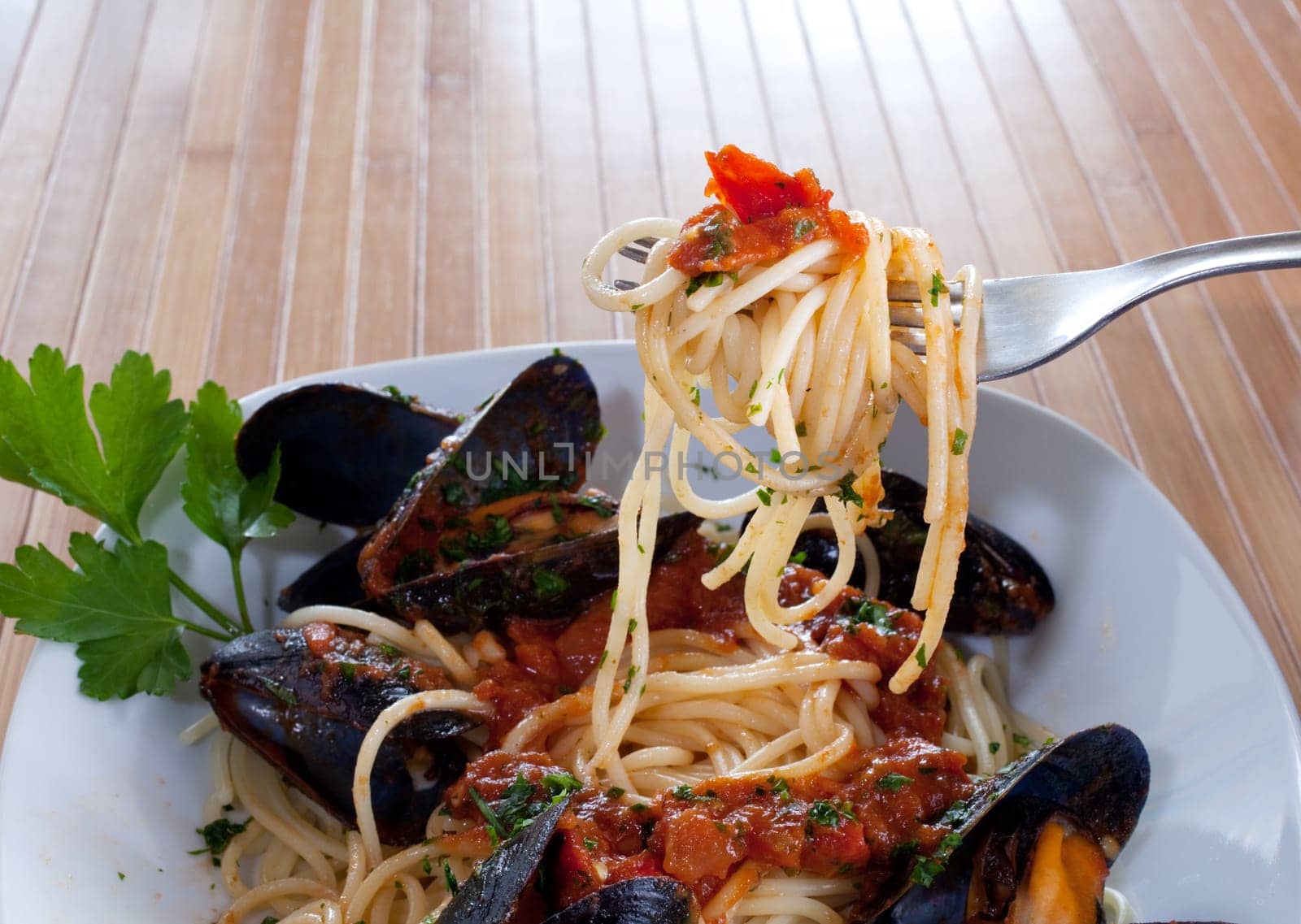 Spaghetti with mussels on wooden table
