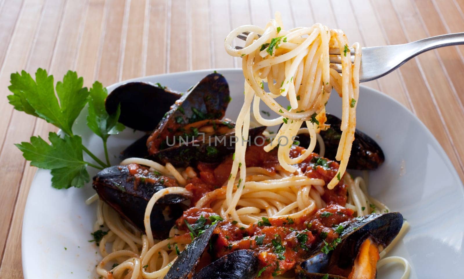 Spaghetti with mussels on wooden table