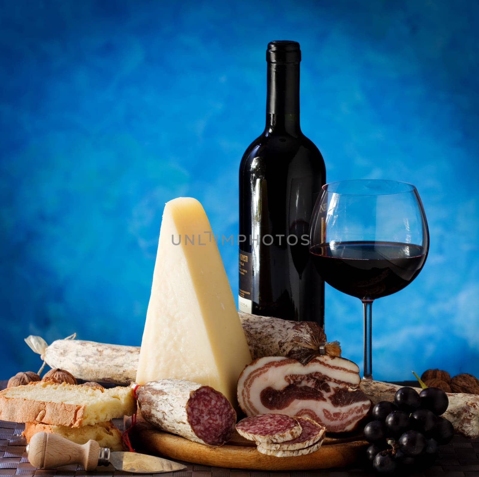 Salumi armiggiano cheese,  and glass of red wine on purple background