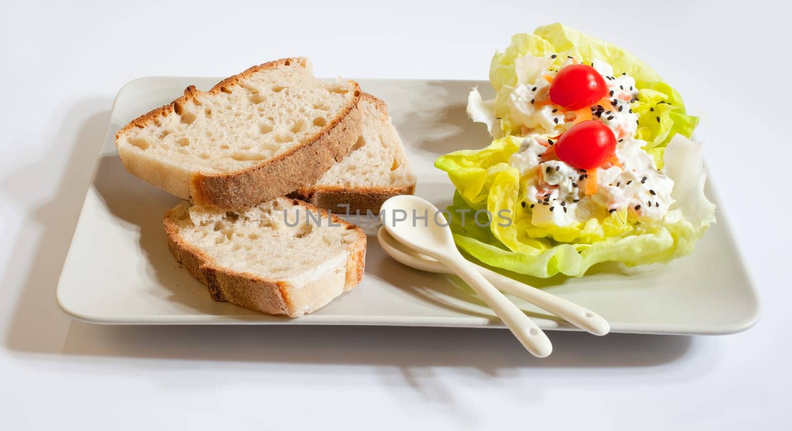 Bread and fresh salad on white