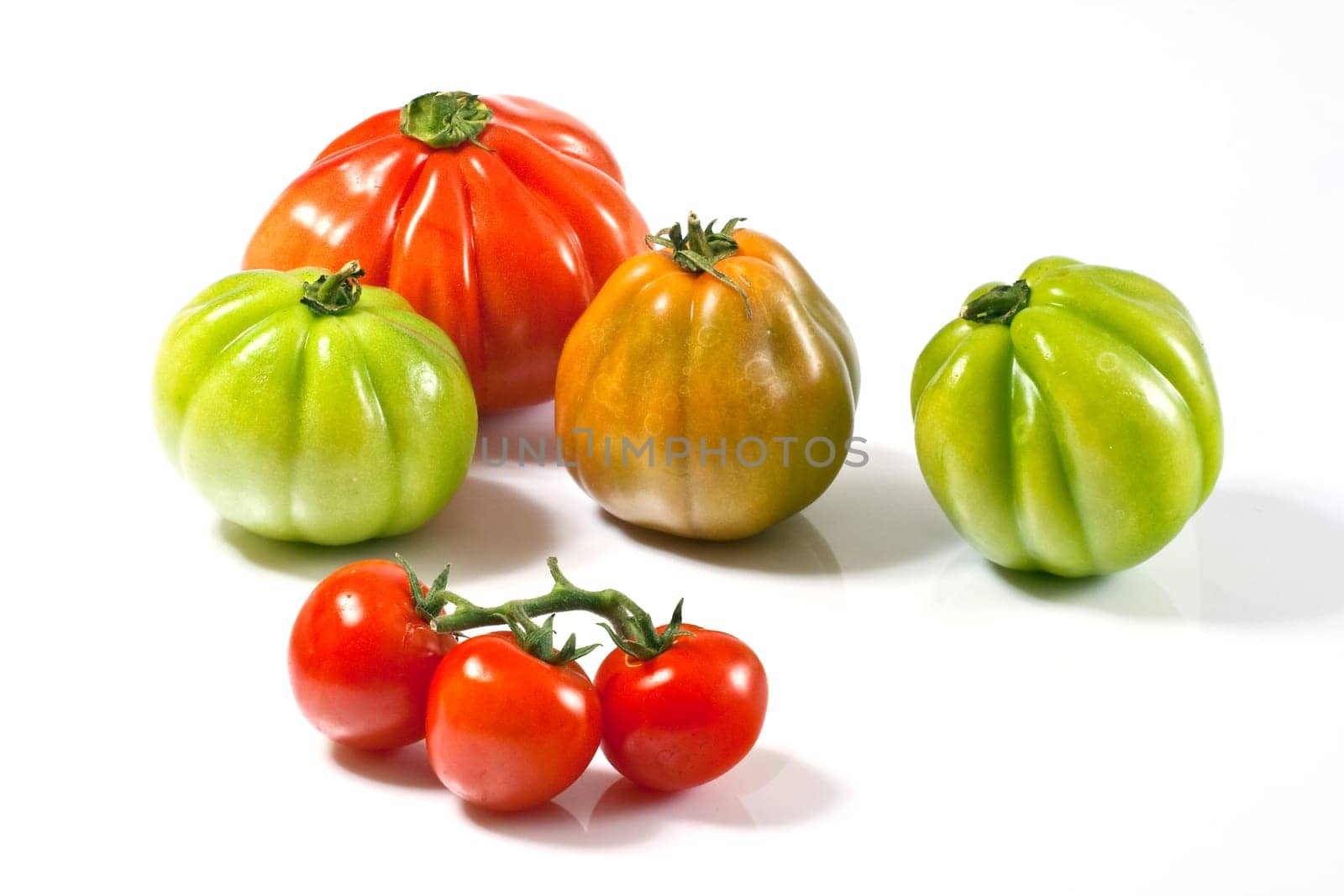 Various fresh tomatoes on a white background