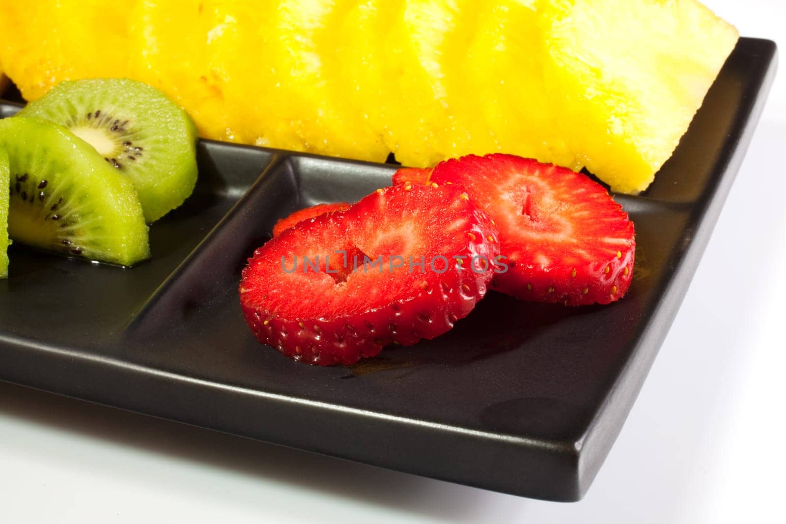 Sliced fruits on black saucer
