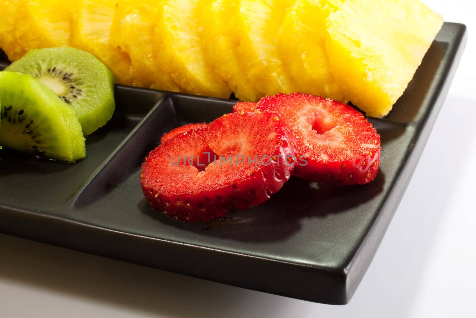 Sliced fruits on black saucer