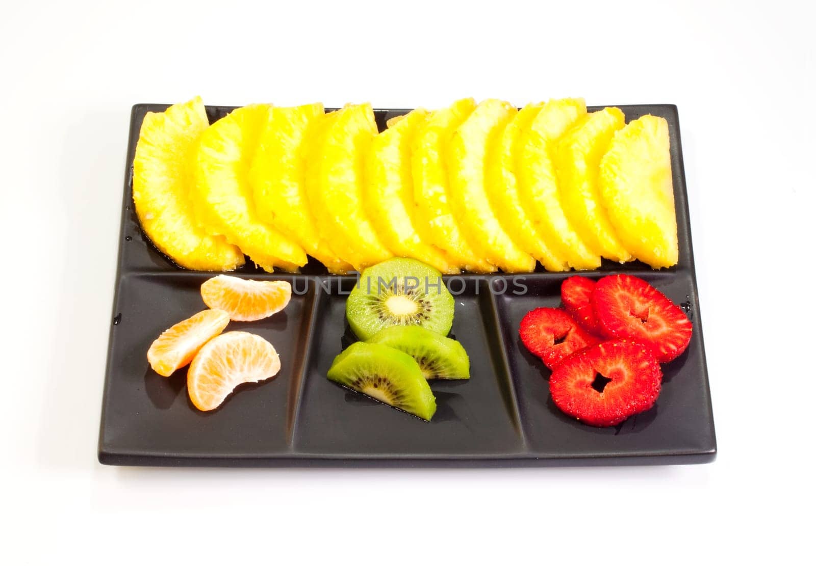 Sliced fruits on black saucer