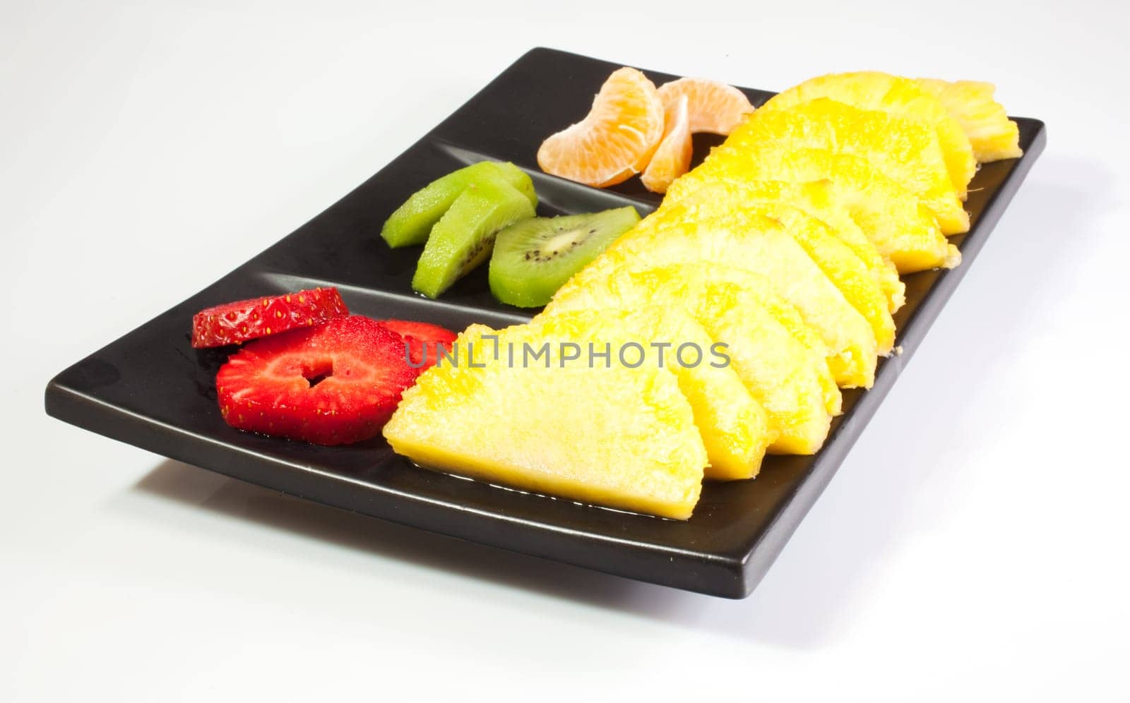 Sliced fruits on black saucer