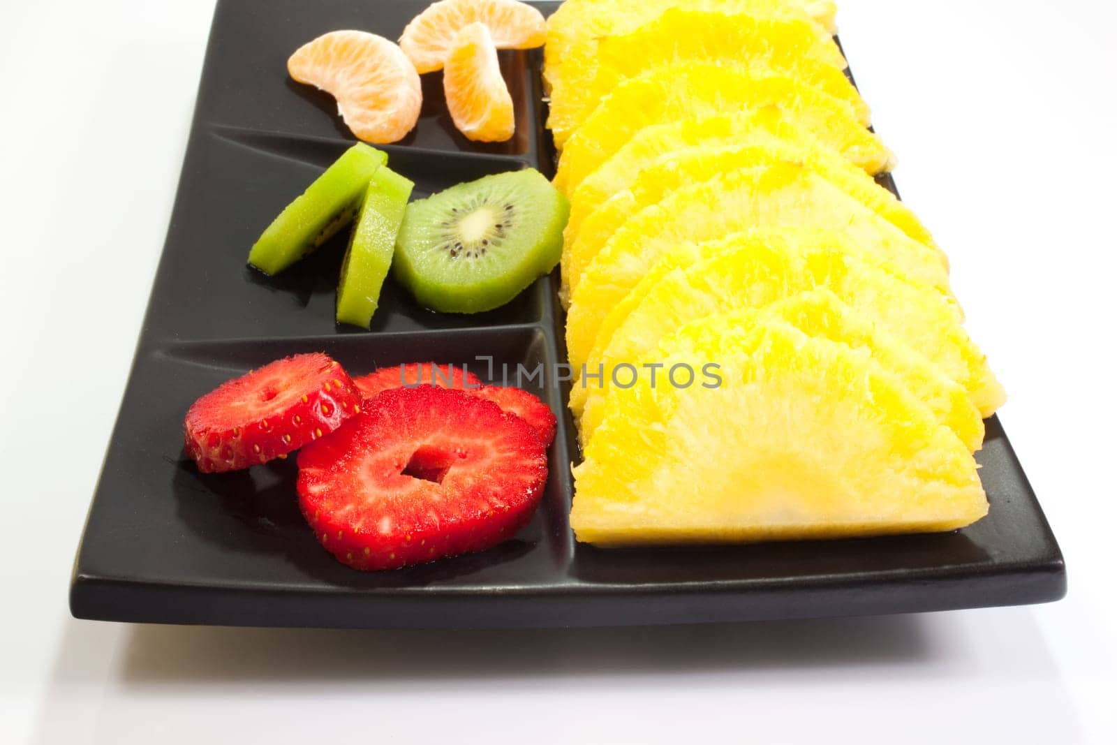 Sliced fruits on black saucer