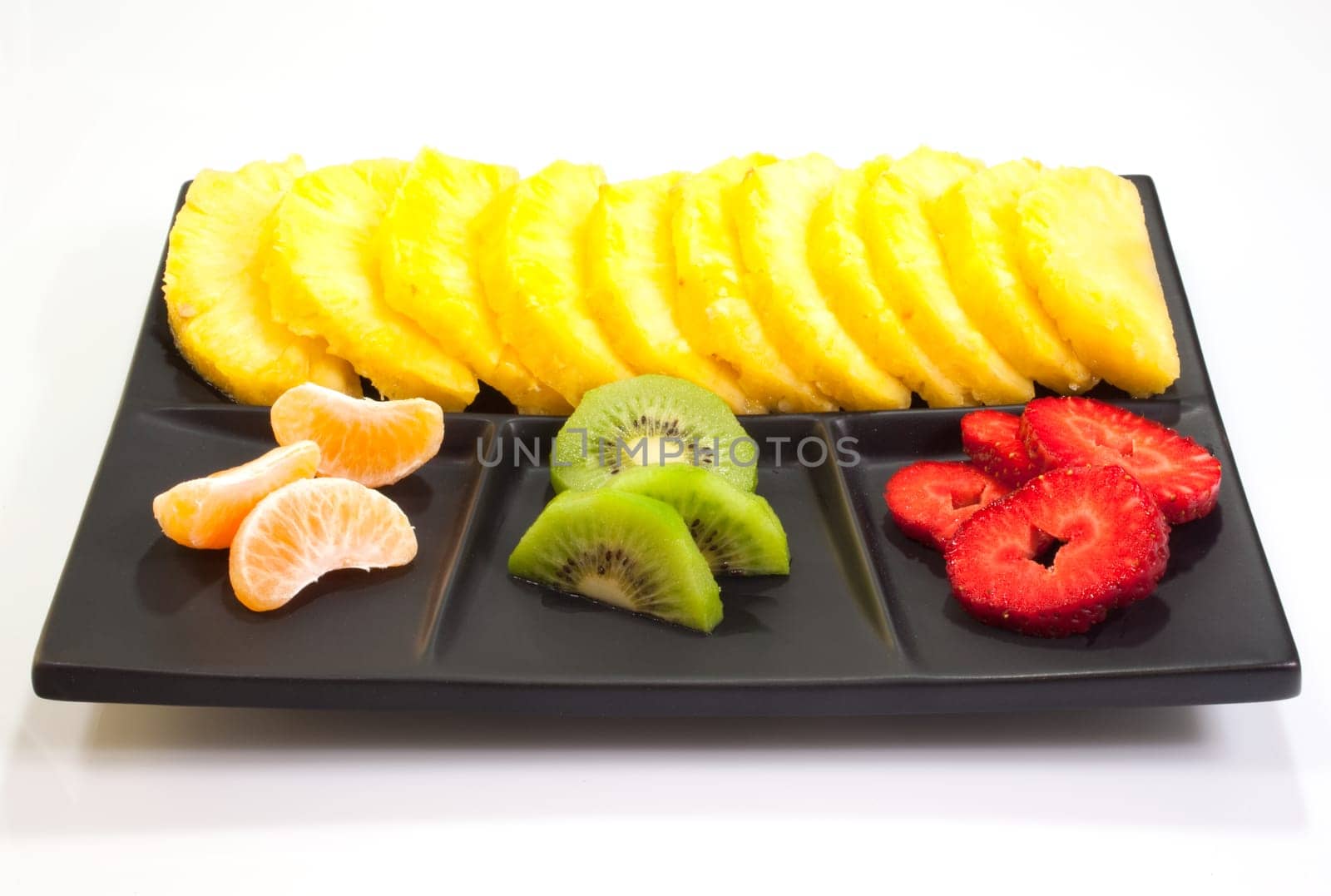 Sliced fruits on black saucer