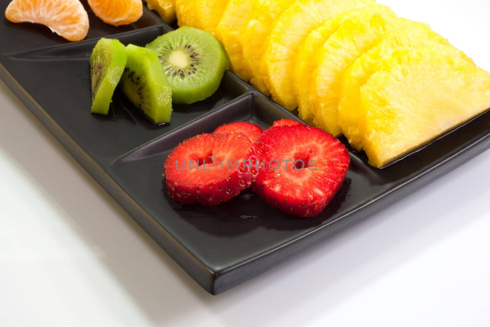 Sliced fruits on black saucer
