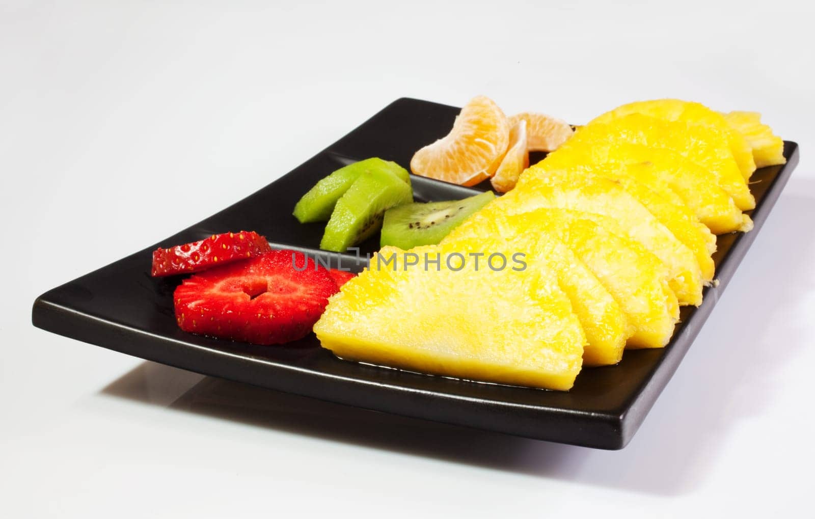 Sliced fruits on black saucer