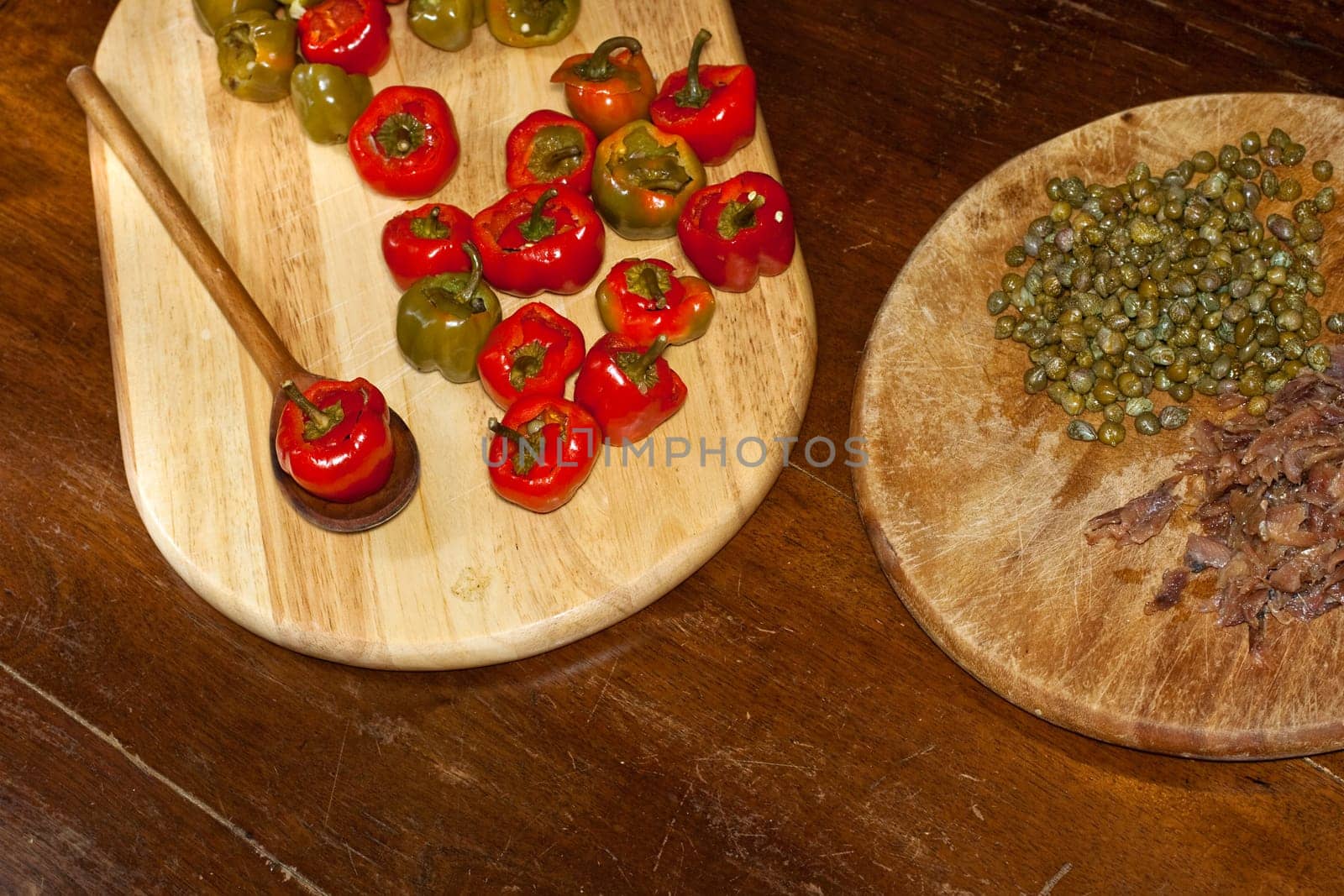 Red hot chili peppers on cutting board, capers and anchovies