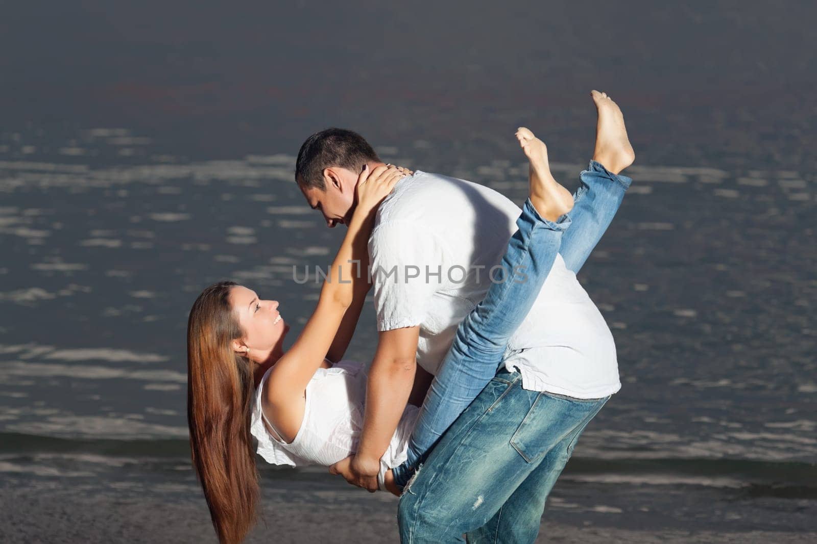 Young couple near the sea at sunrise