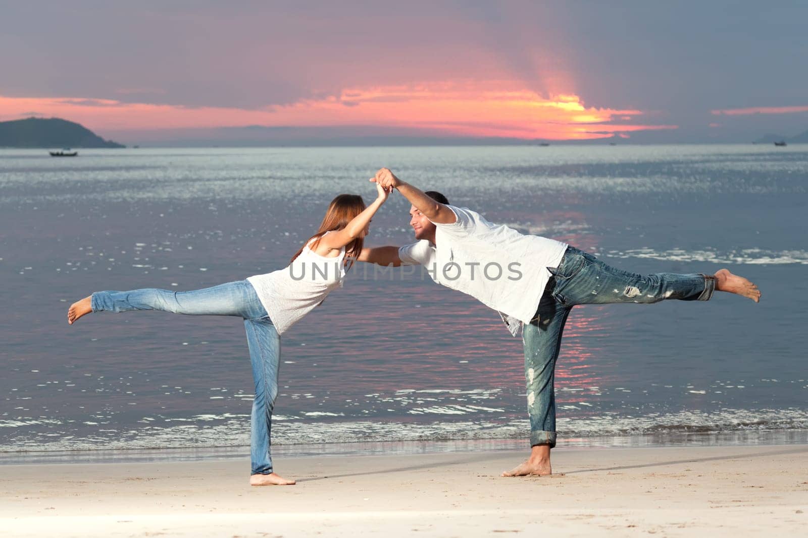 Young couple near the sea at sunrise