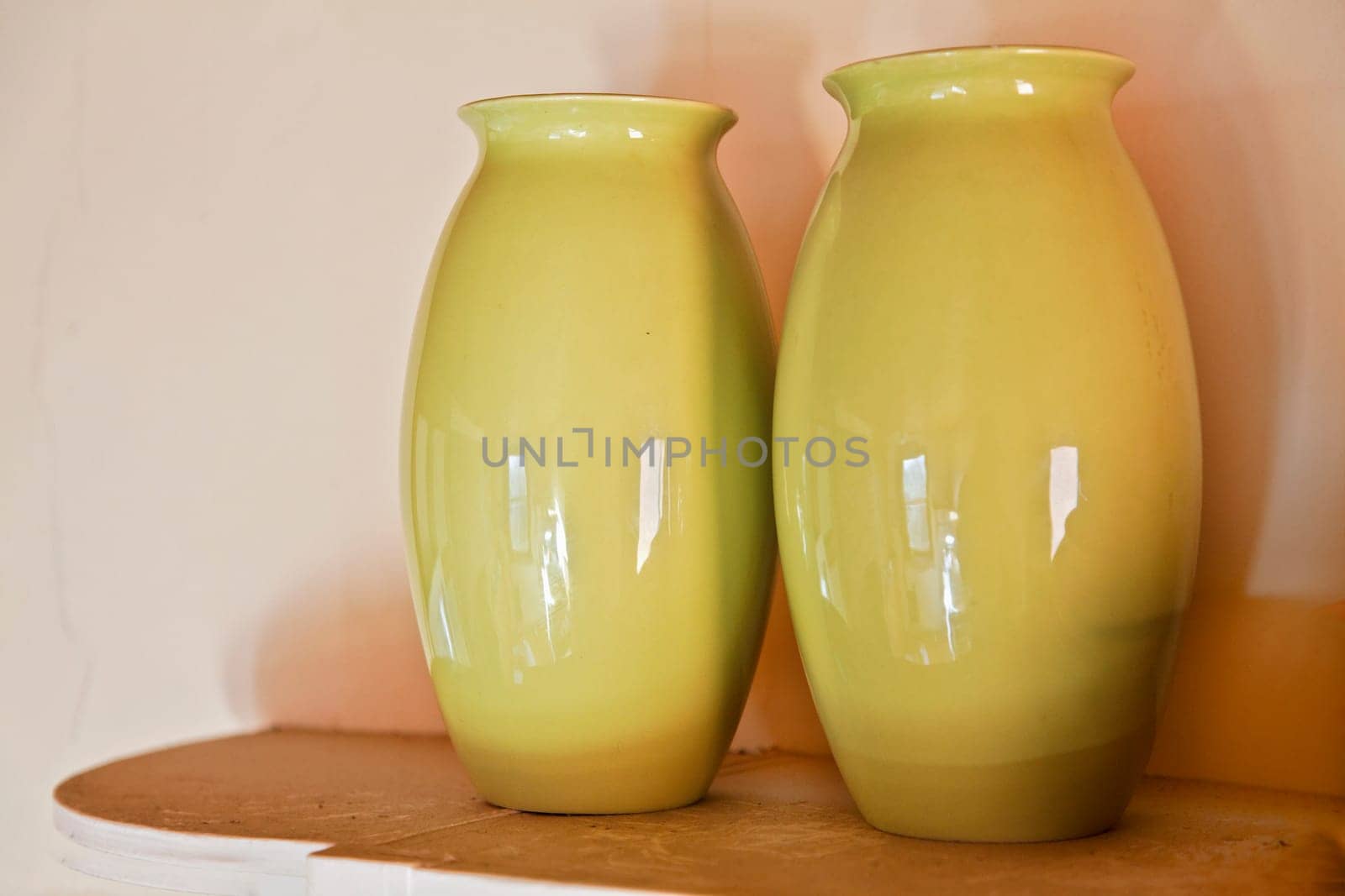 Two olive green vases on a cottage shelf, part of a set crockery set