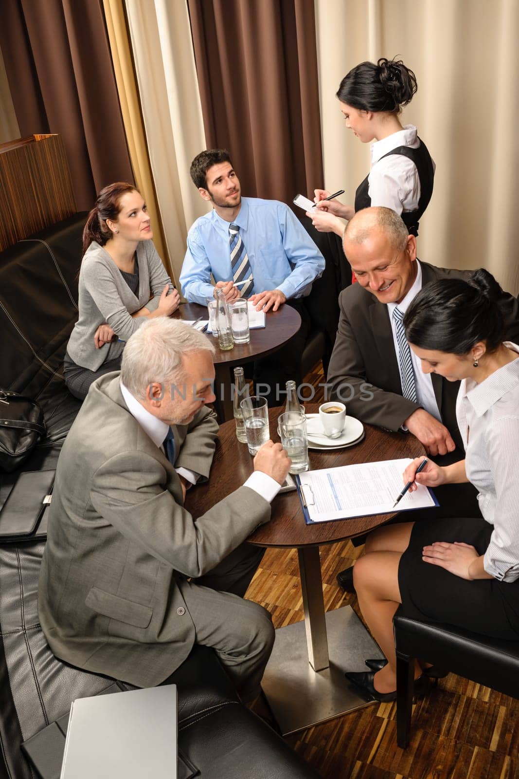 Business people having a company meeting at restaurant waitress ordering