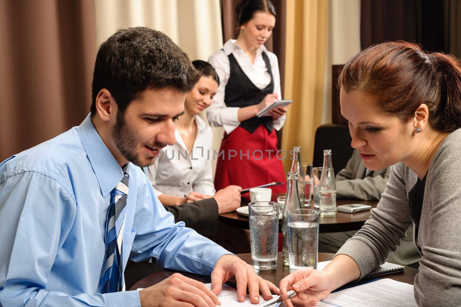 Business people having a company meeting at restaurant waitress ordering