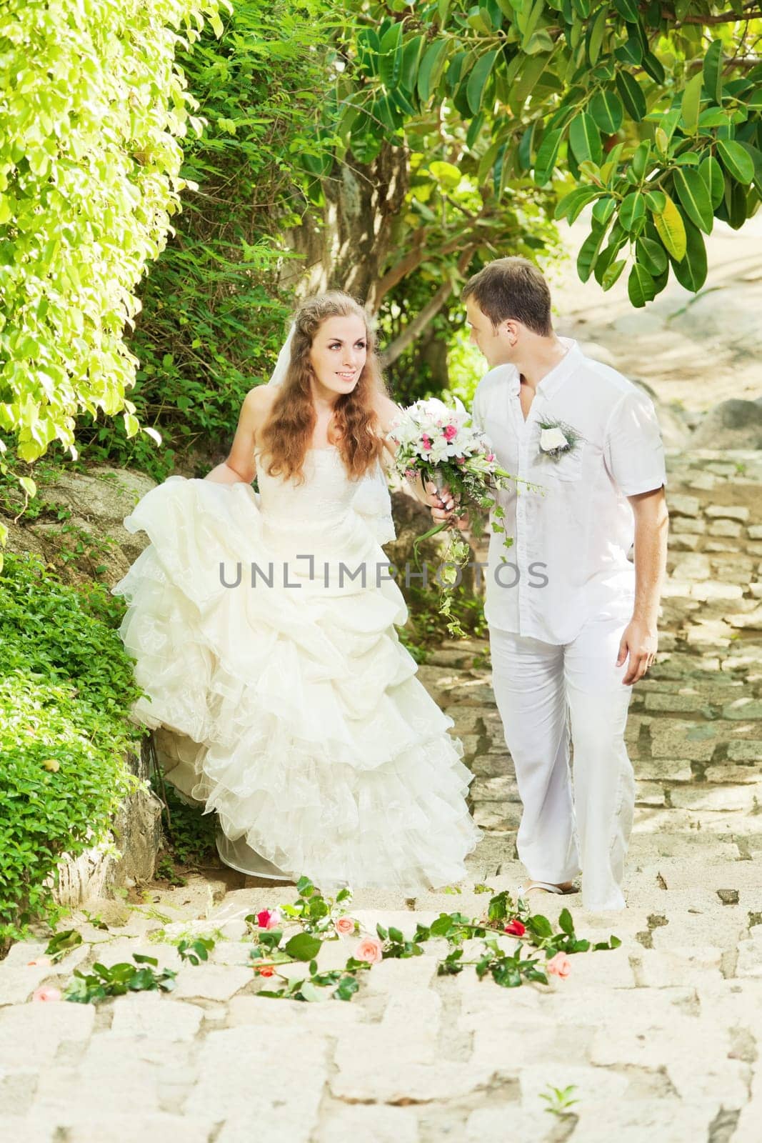Bride and groom in a tropical garden.