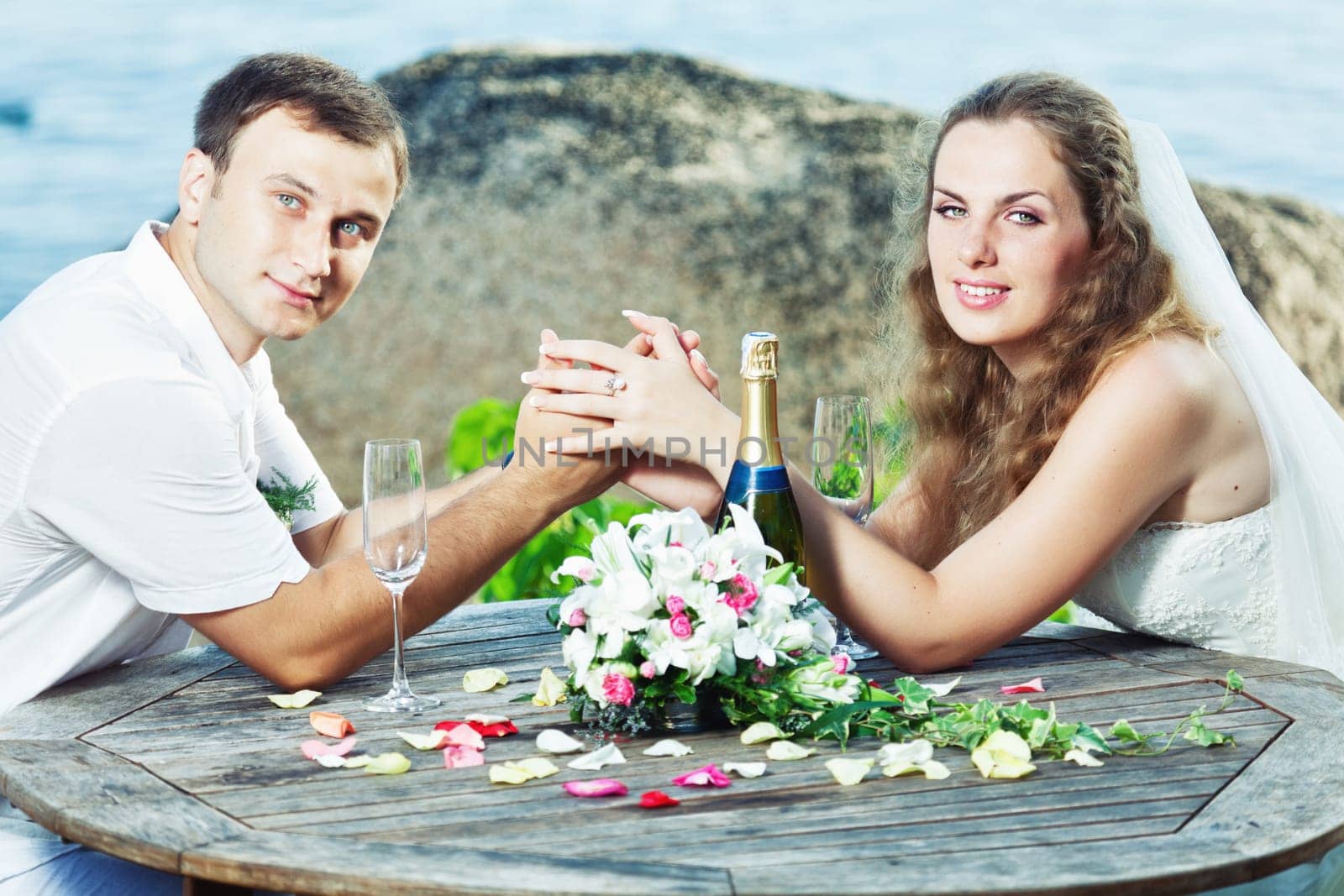 Bride and groom at wedding table near the sea
