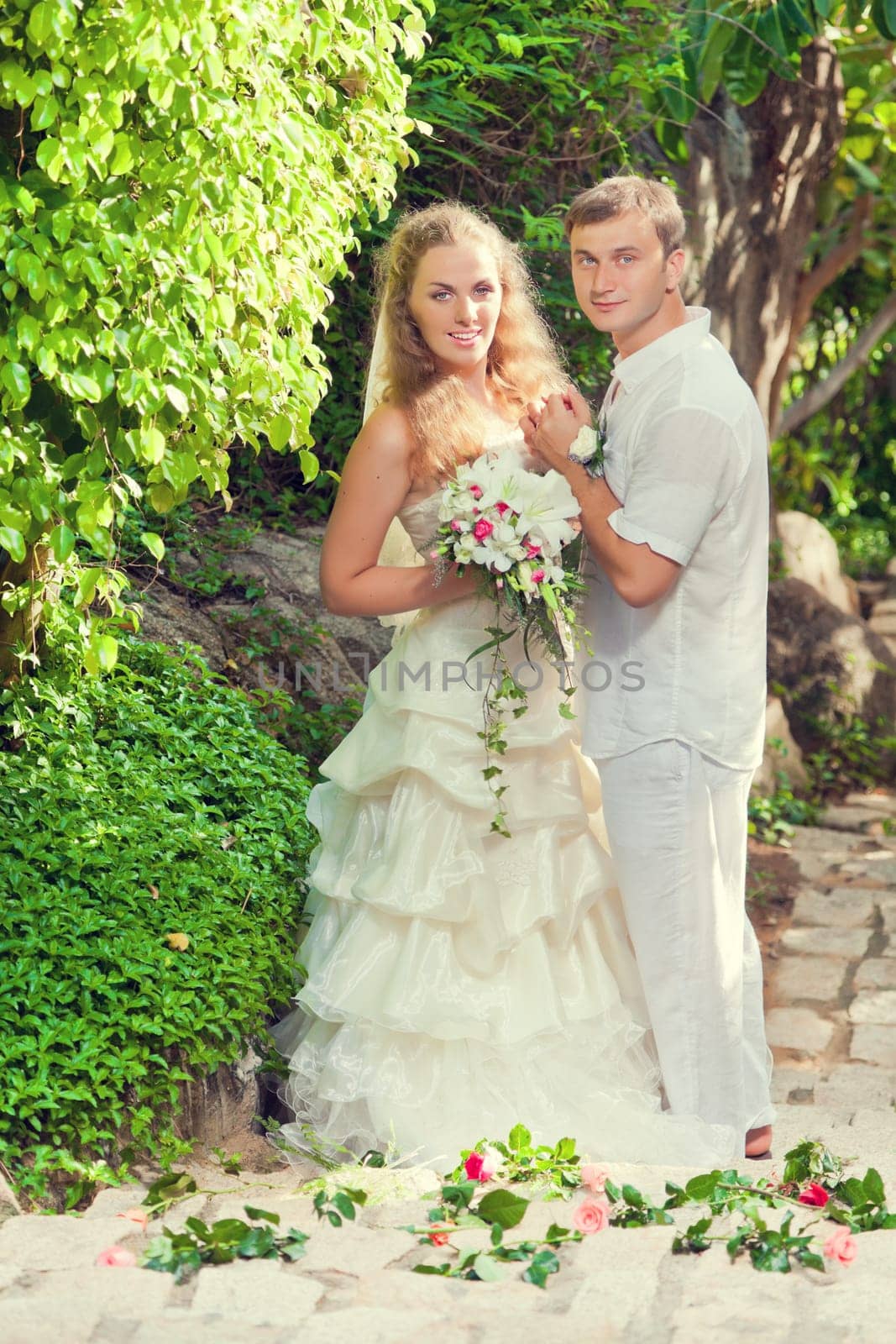 Bride and groom in a tropical garden.