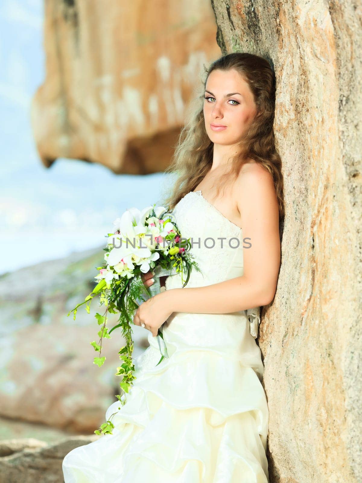 Beautiful bride with bouquet near the sea