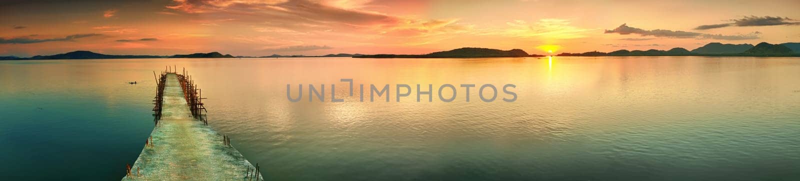 Sunset over the sea. Pier on the foreground. Panorama