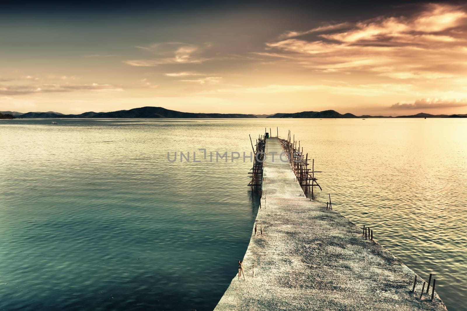 Sunrise over the sea. Pier on the foreground