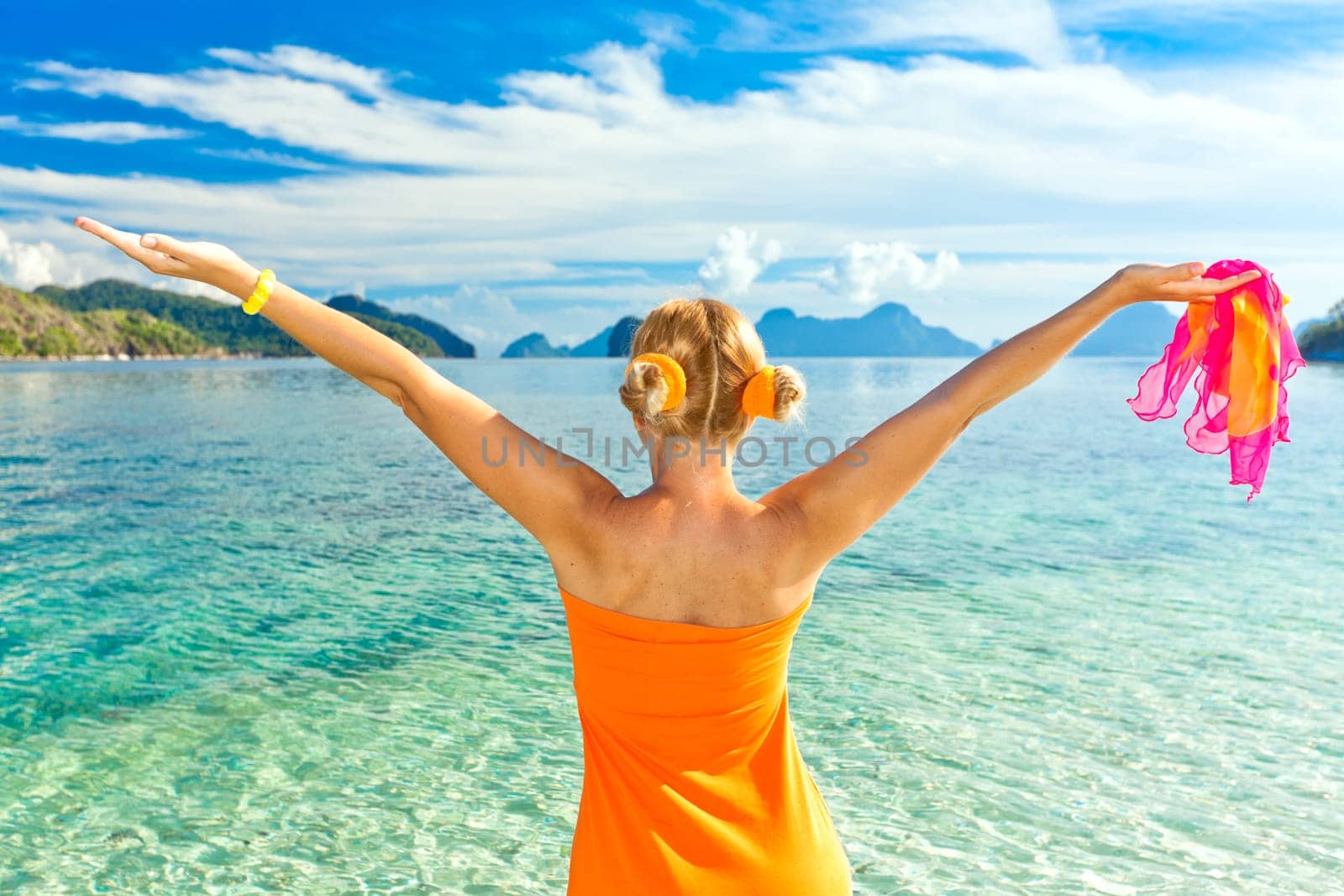 Woman in orange dress with raised hands